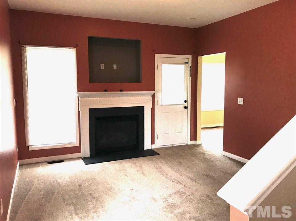 3832 Pin Oak Road Raleigh, NC 27604 - Photo 7 of 14 a view of an empty room with a fireplace and a window