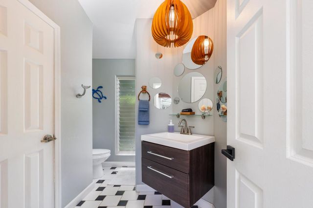 a bathroom with a sink and mirror with toilet