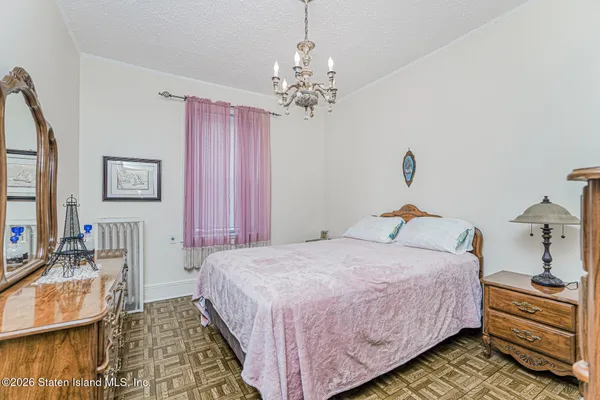 a bedroom with a bed and a chandelier