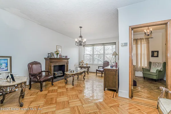 a living room with furniture a fireplace and a chandelier