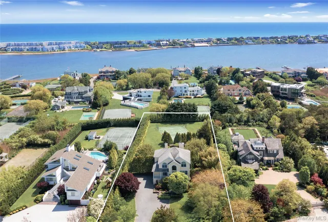 an aerial view of a city with lots of residential buildings ocean and mountain view in back