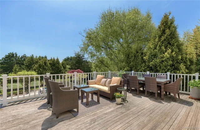 a view of roof deck with furniture and trees