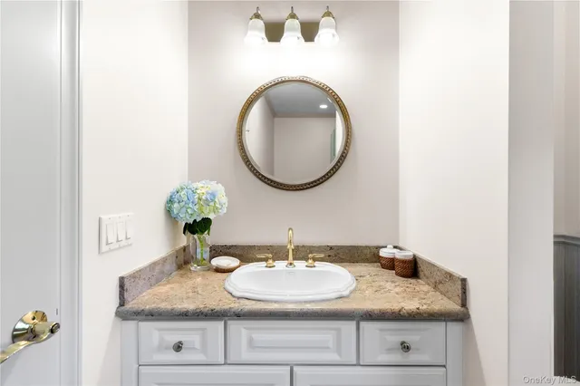 a bathroom with a granite countertop sink and a mirror
