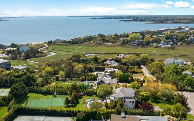 an aerial view of ocean and residential houses with outdoor space