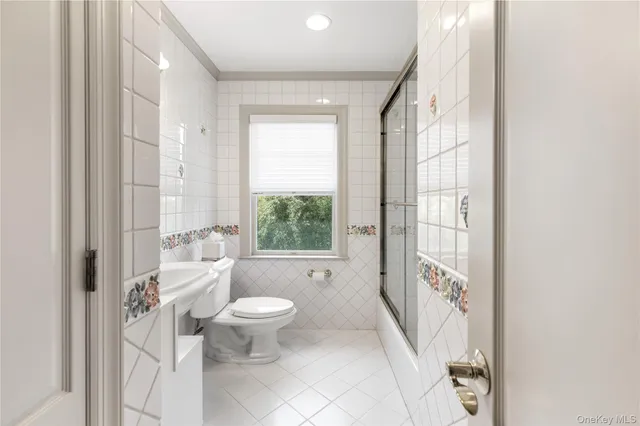 a bathroom with a toilet sink and a large mirror