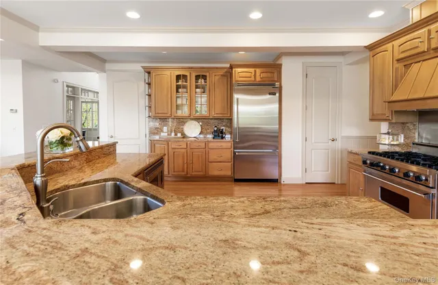a kitchen with stainless steel appliances granite countertop a sink stove and refrigerator