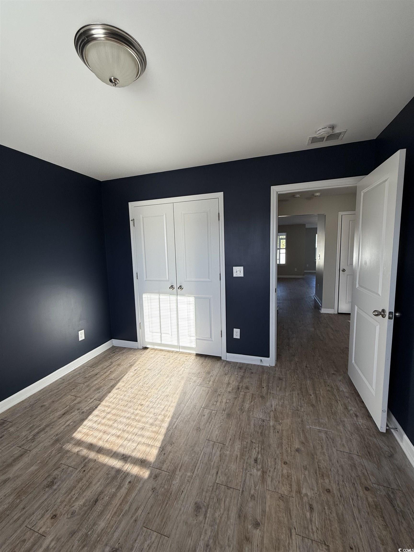 462 Quinta Street Longs, SC 29568 - Photo 18 of 39 Unfurnished bedroom featuring a closet and dark wood-style floors