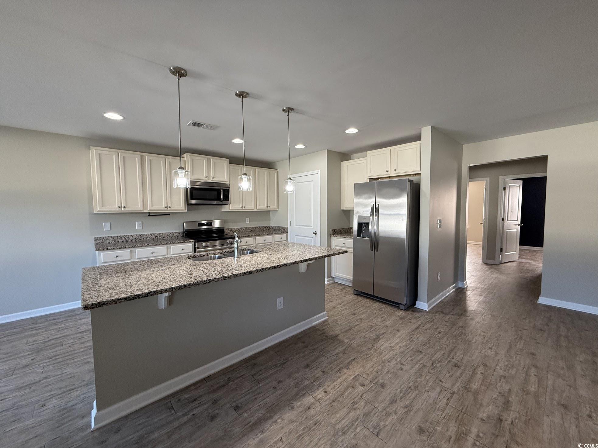 462 Quinta Street Longs, SC 29568 - Photo 8 of 39 Kitchen featuring recessed lighting, appliances with stainless steel finishes, dark stone counters, decorative light fixtures, and a center island with sink