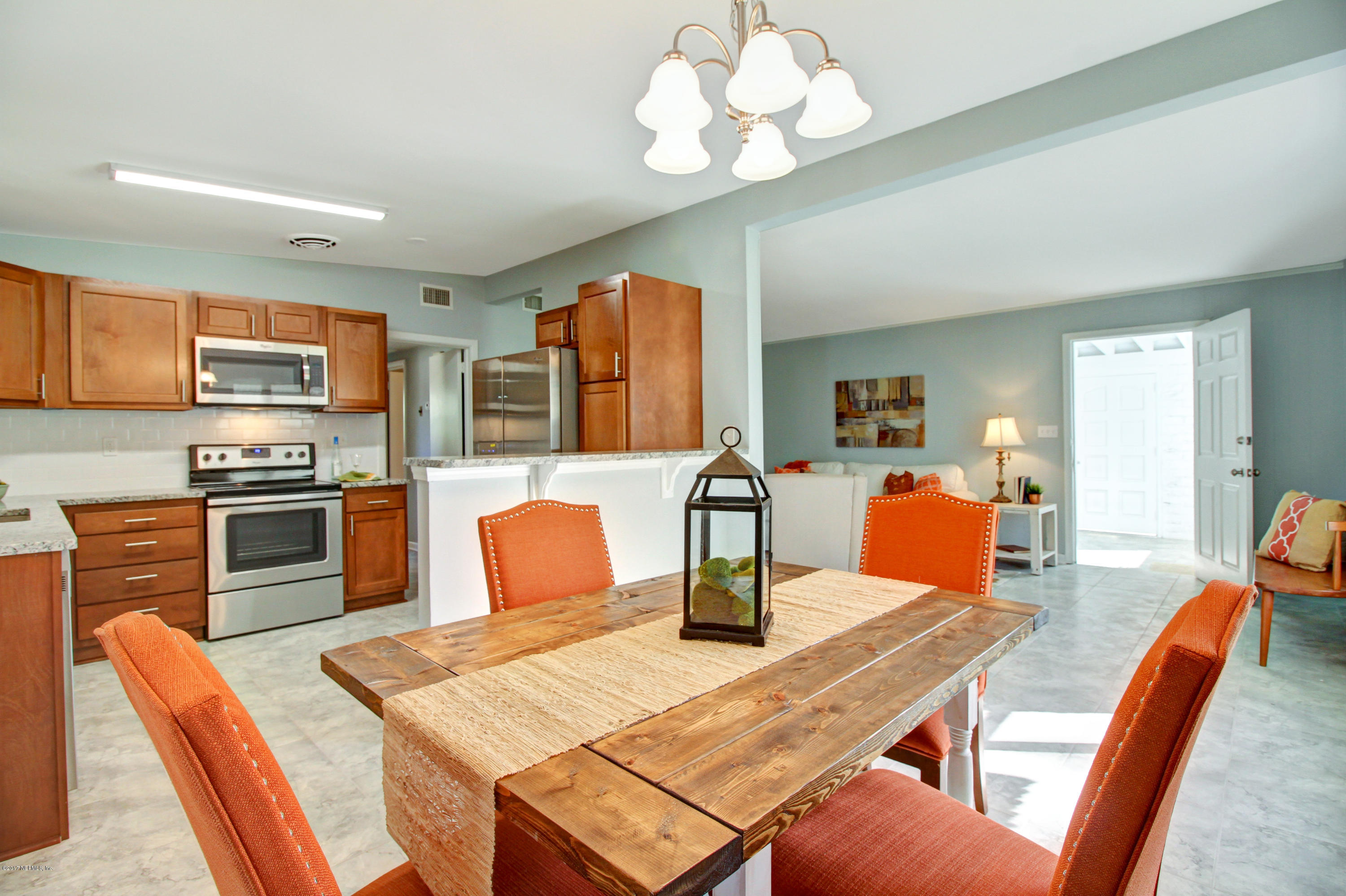 7003 Arques Road Jacksonville, FL 32205 - Photo 15 of 24 a view of a dining room with furniture a chandelier and wooden floor