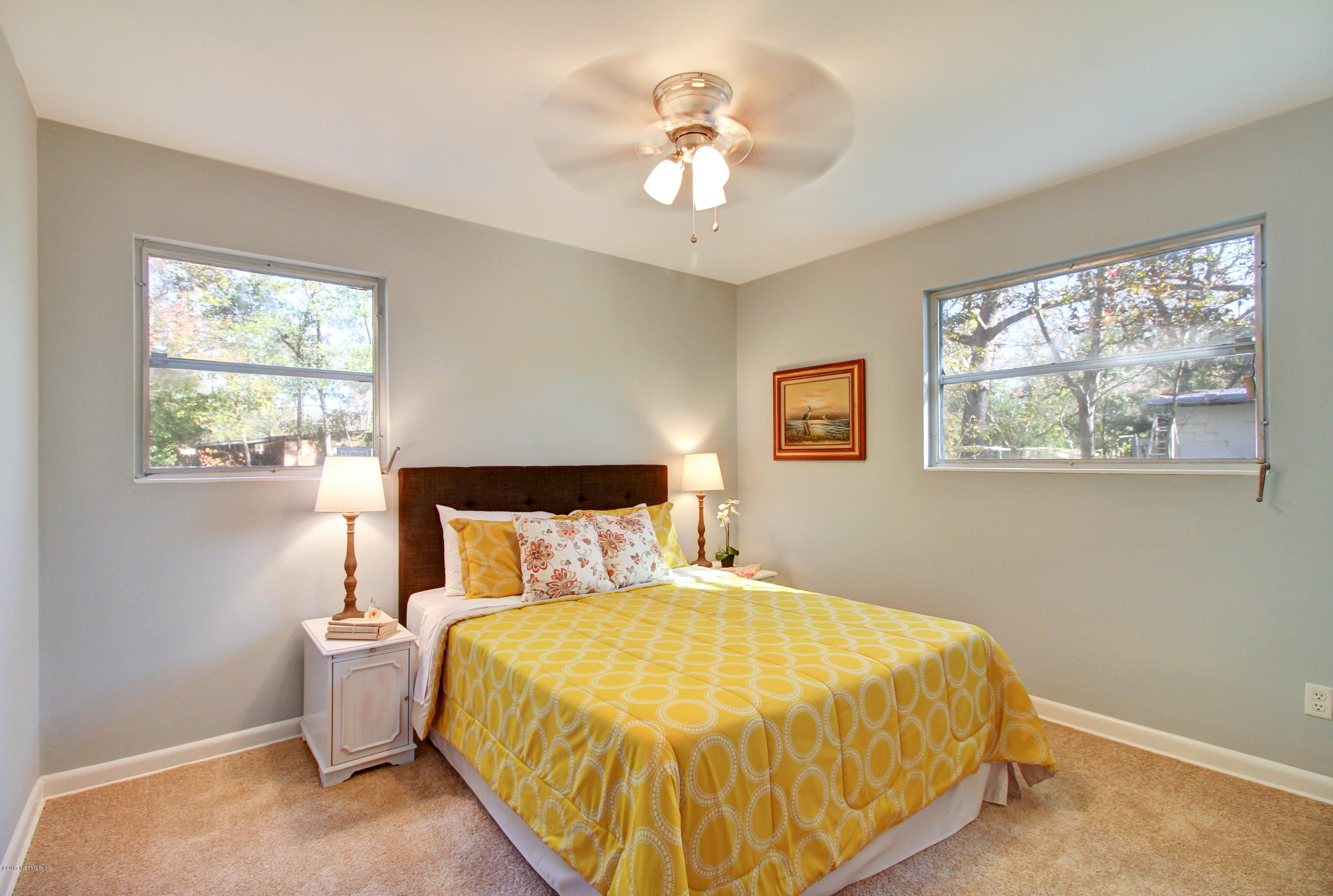7003 Arques Road Jacksonville, FL 32205 - Photo 23 of 24 a bedroom with a bed and a chandelier