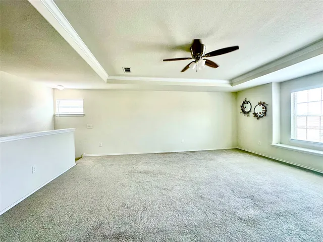 an empty room with windows and fan