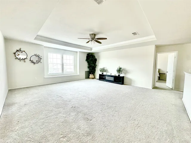 an empty room with windows and ceiling fan