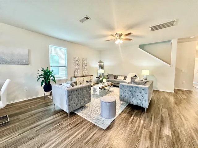 a living room with furniture and wooden floor