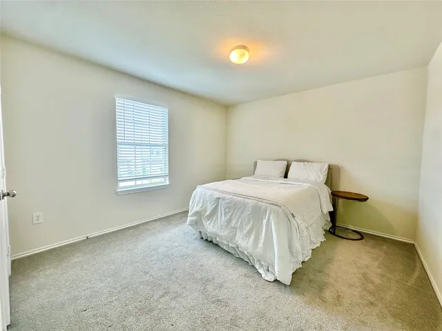 a spacious bedroom with a bed and a window