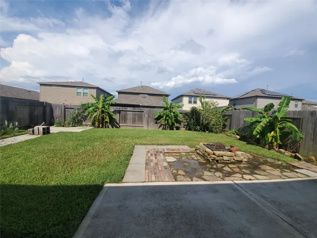 a view of a yard with flower plants and wooden fence