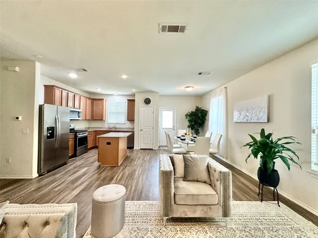 a living room with furniture kitchen view and a potted plant