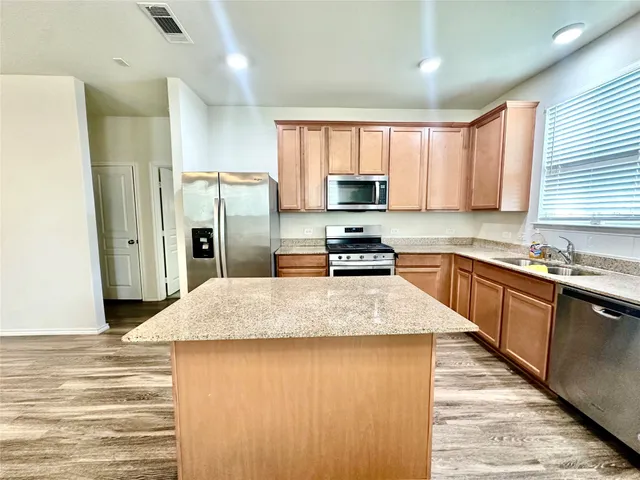 a kitchen with stainless steel appliances granite countertop a refrigerator sink and cabinets