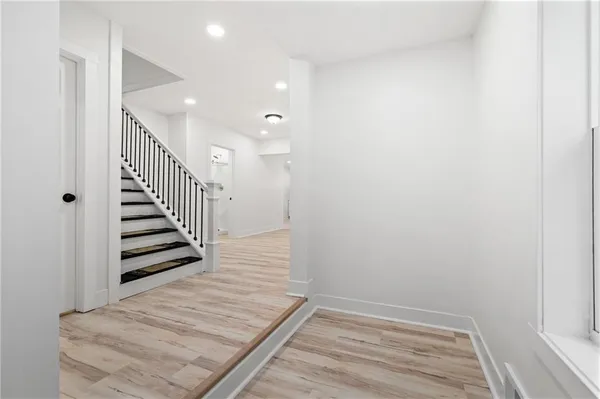 a view of a hallway with stairs and wooden floor