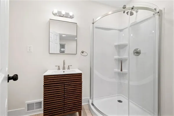 a bathroom with a sink a mirror and a shower