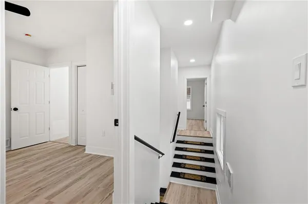 a view of a hallway with wooden floor and white walls