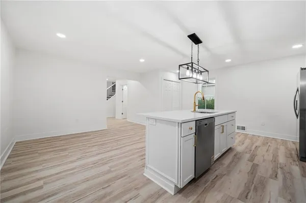 a kitchen with kitchen island a sink and wooden floor