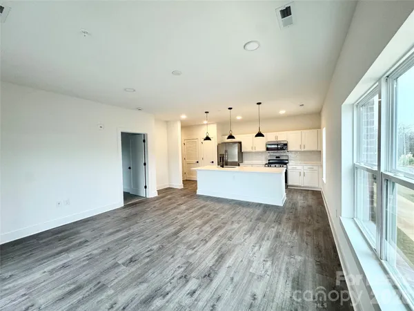 a view of a kitchen with wooden floor and windows
