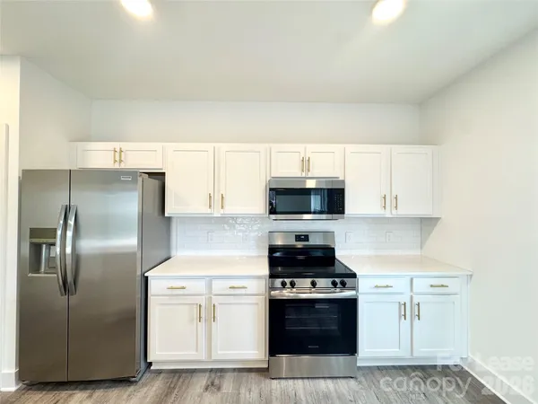 a kitchen with stainless steel appliances a refrigerator stove and microwave