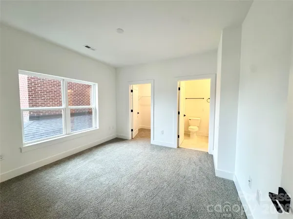 an empty room with windows and closet