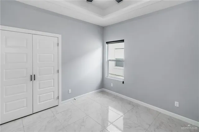an empty room with closet and a chandelier fan