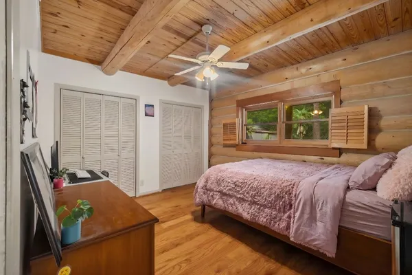 a bedroom with a bed dresser and a large window