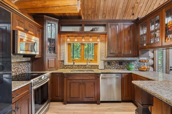 a kitchen with stainless steel appliances granite countertop a sink and a stove