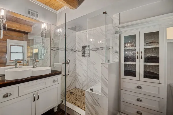 a bathroom with a shower sink and mirror