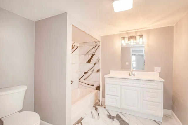 a bathroom with a sink a toilet and tub