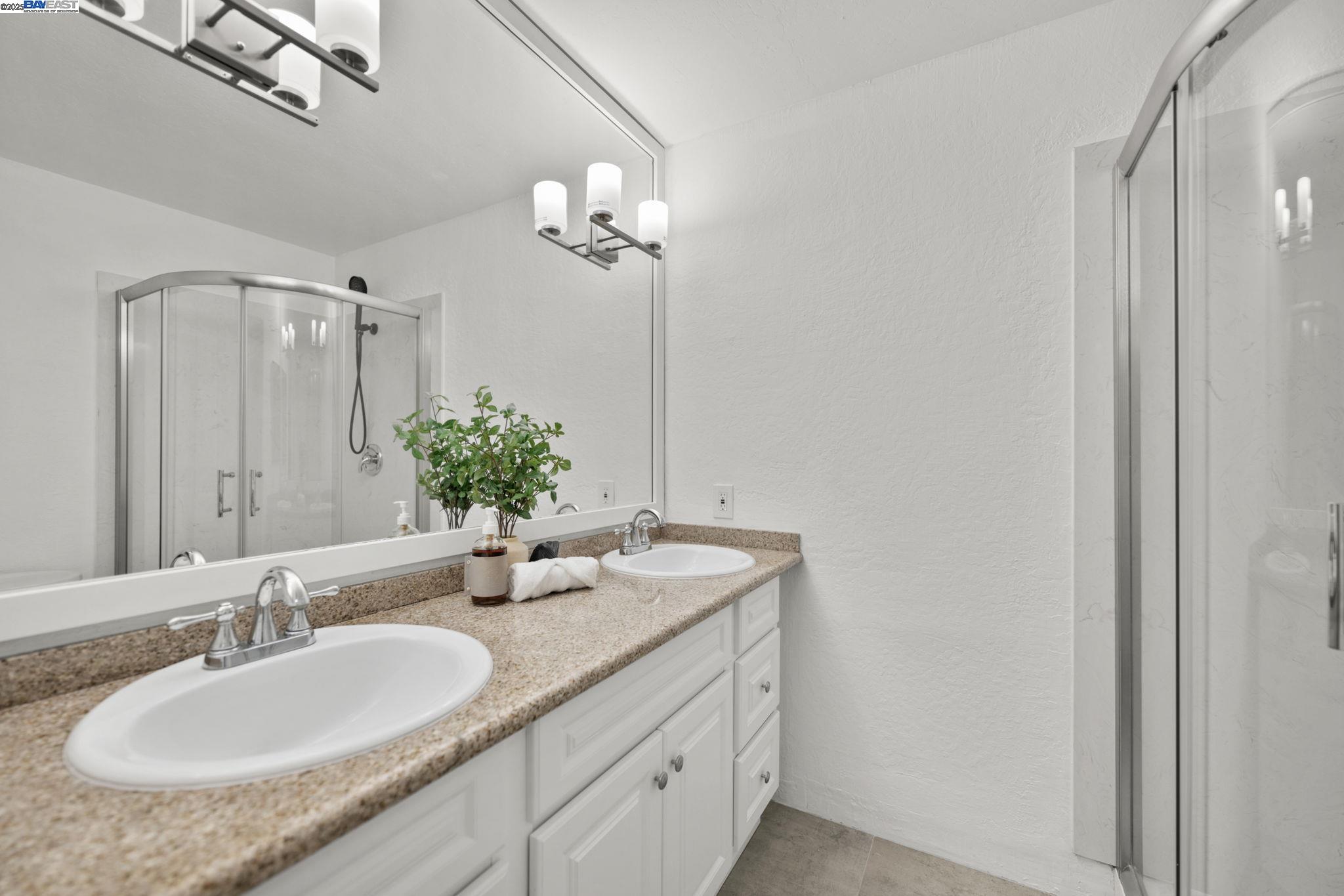 1085 Murrieta Boulevard, Unit 222 Livermore, CA 94550 - Photo 18 of 25 a bathroom with a granite countertop sink and a mirror