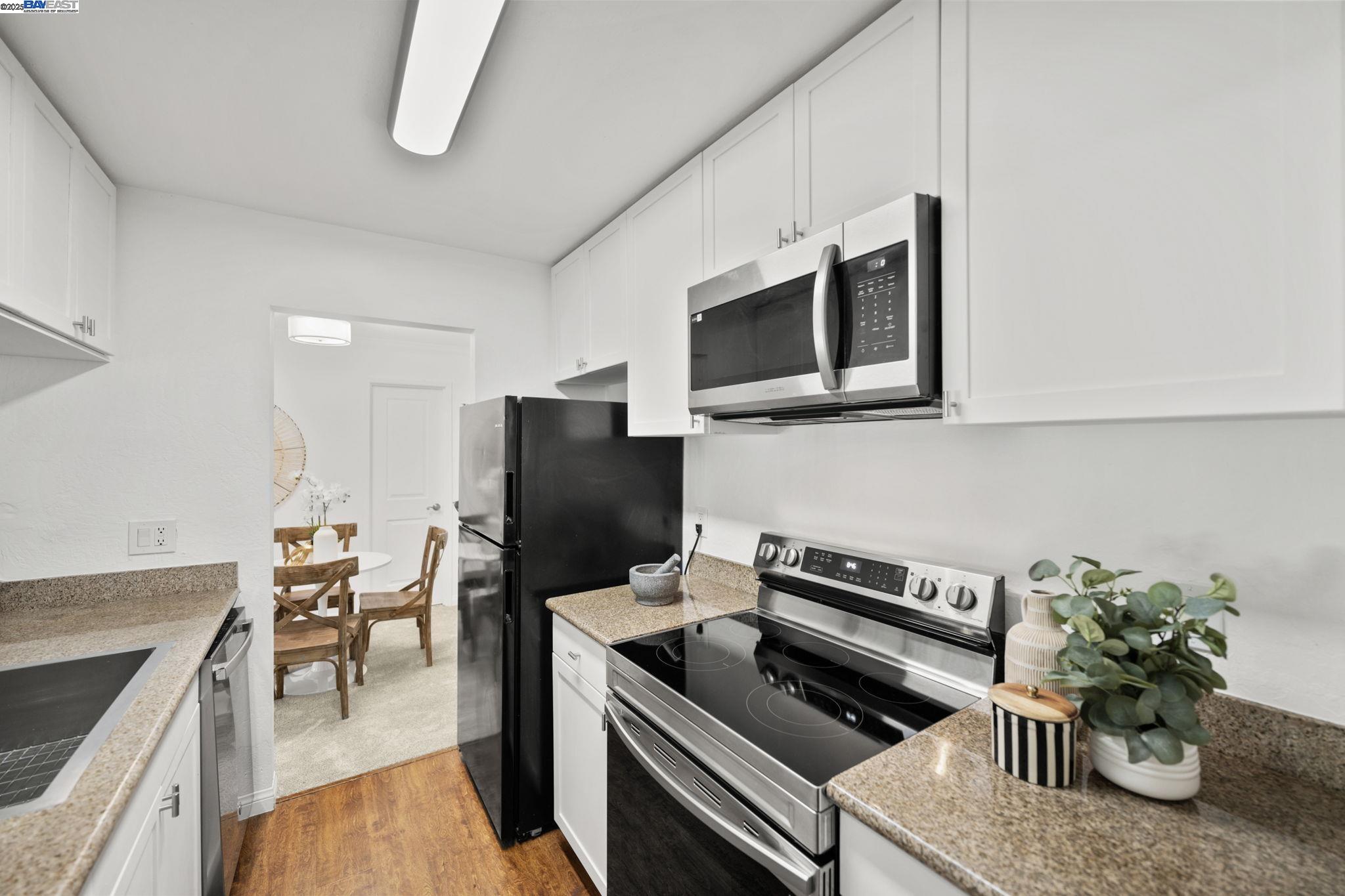 1085 Murrieta Boulevard, Unit 222 Livermore, CA 94550 - Photo 2 of 25 a kitchen with a refrigerator and a stove top oven