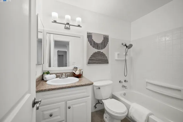 a bathroom with a granite countertop sink toilet a mirror and shower