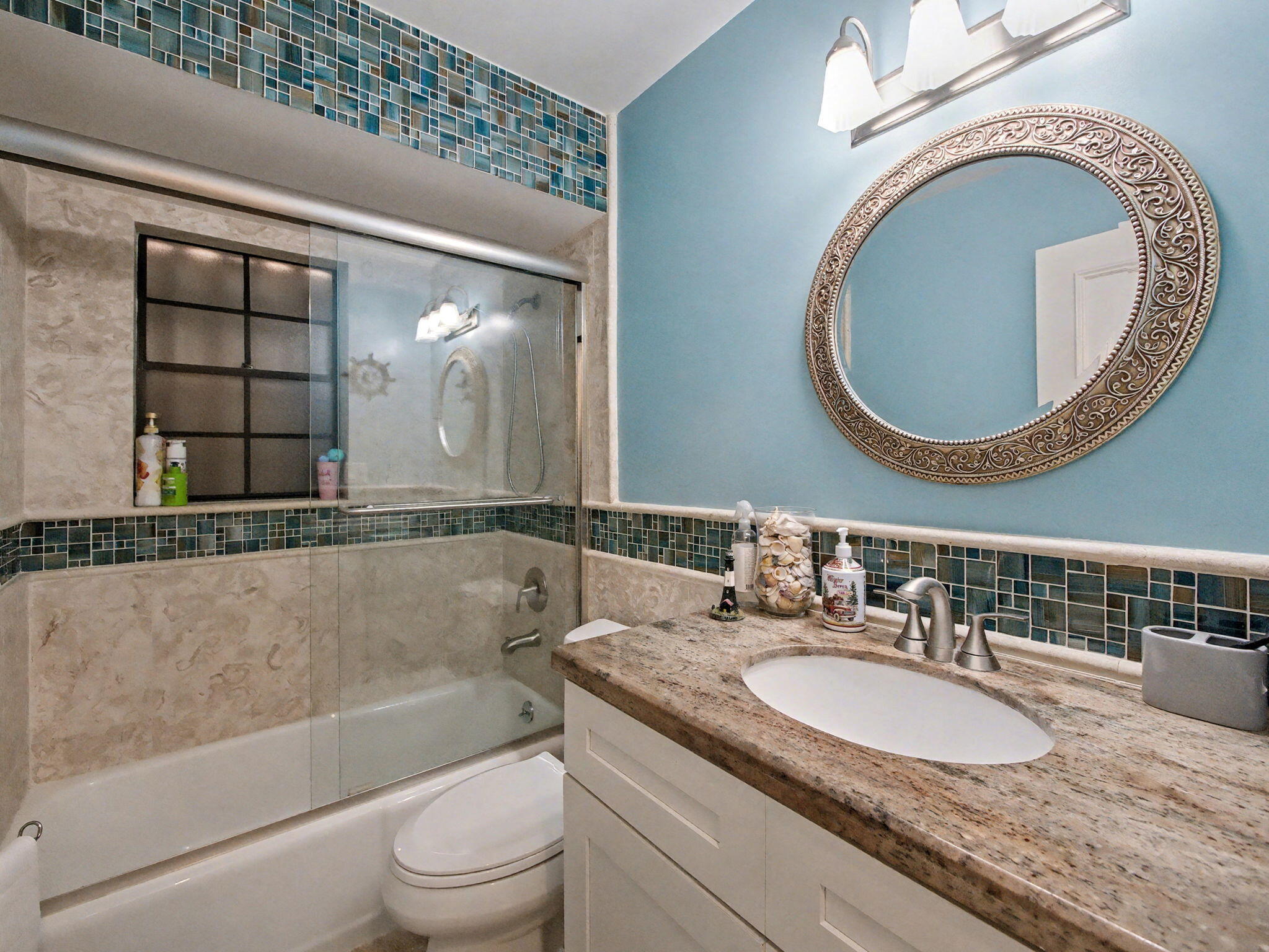 720 Muirfield Circle Atlantis, FL 33462 - Photo 16 of 20 a bathroom with a granite countertop toilet a sink and a mirror