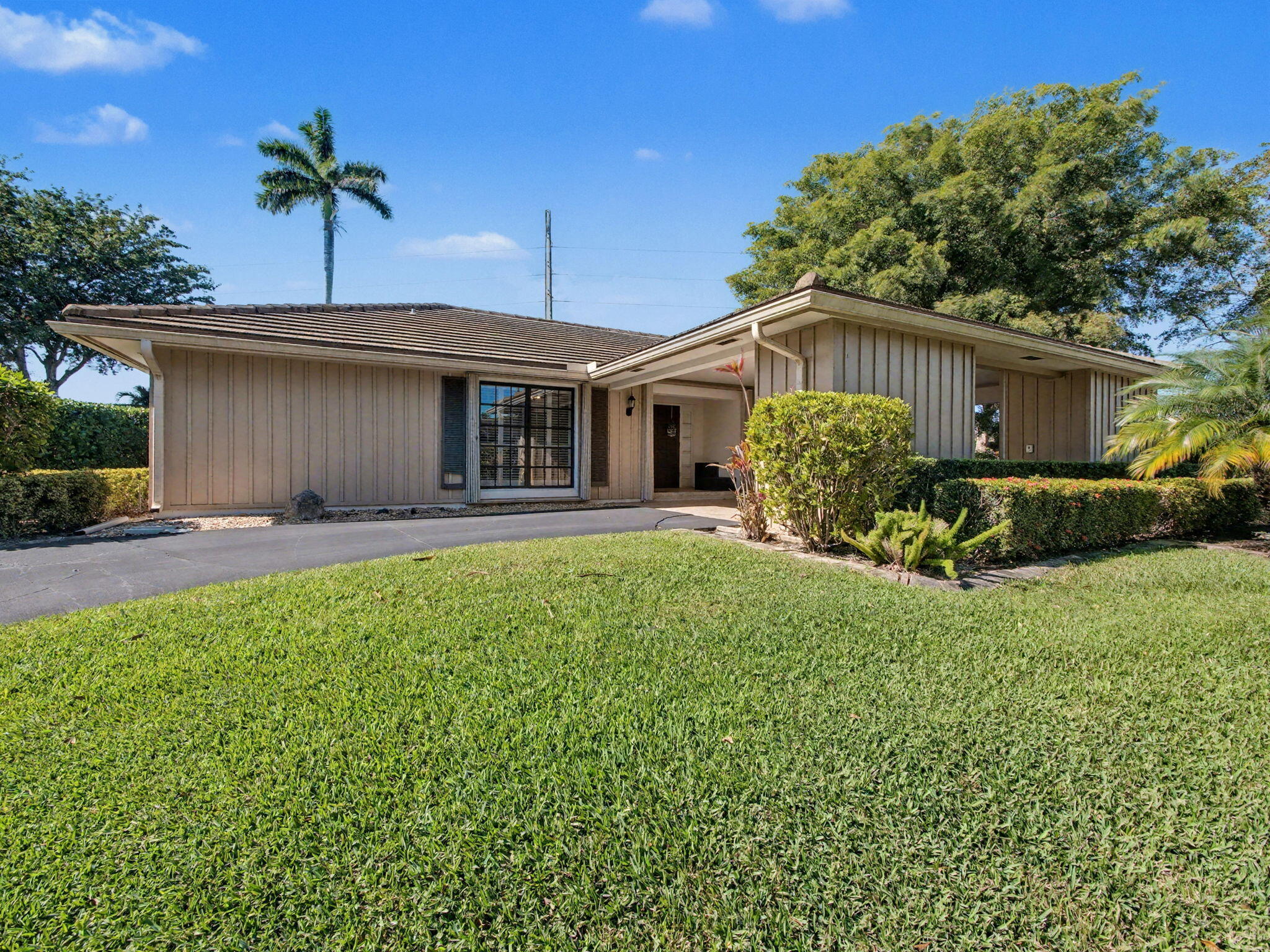 720 Muirfield Circle Atlantis, FL 33462 - Photo 20 of 20 a front view of a house with a garden and plants