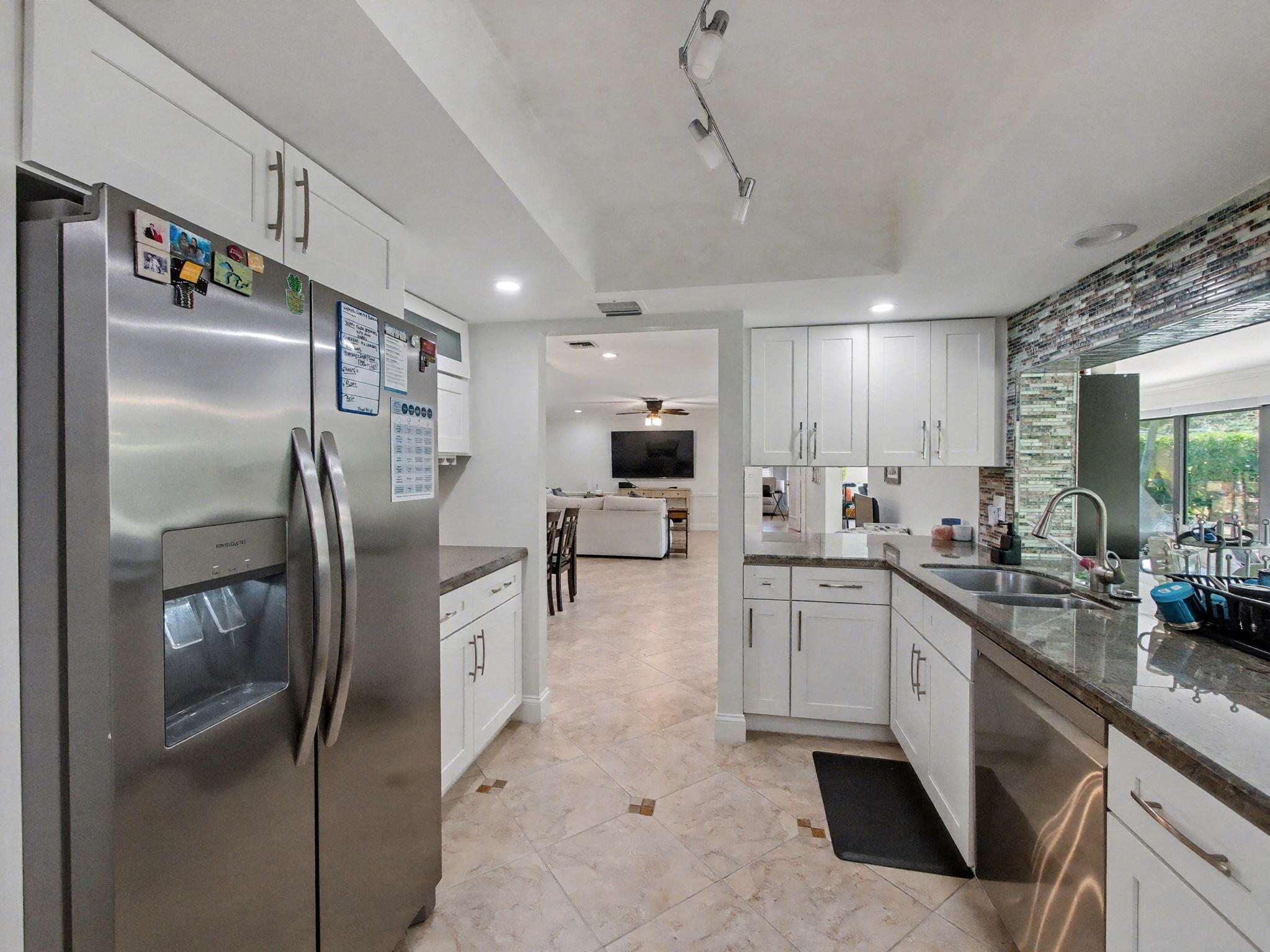 720 Muirfield Circle Atlantis, FL 33462 - Photo 6 of 20 a kitchen with stainless steel appliances granite countertop a refrigerator a sink a stove and white cabinets