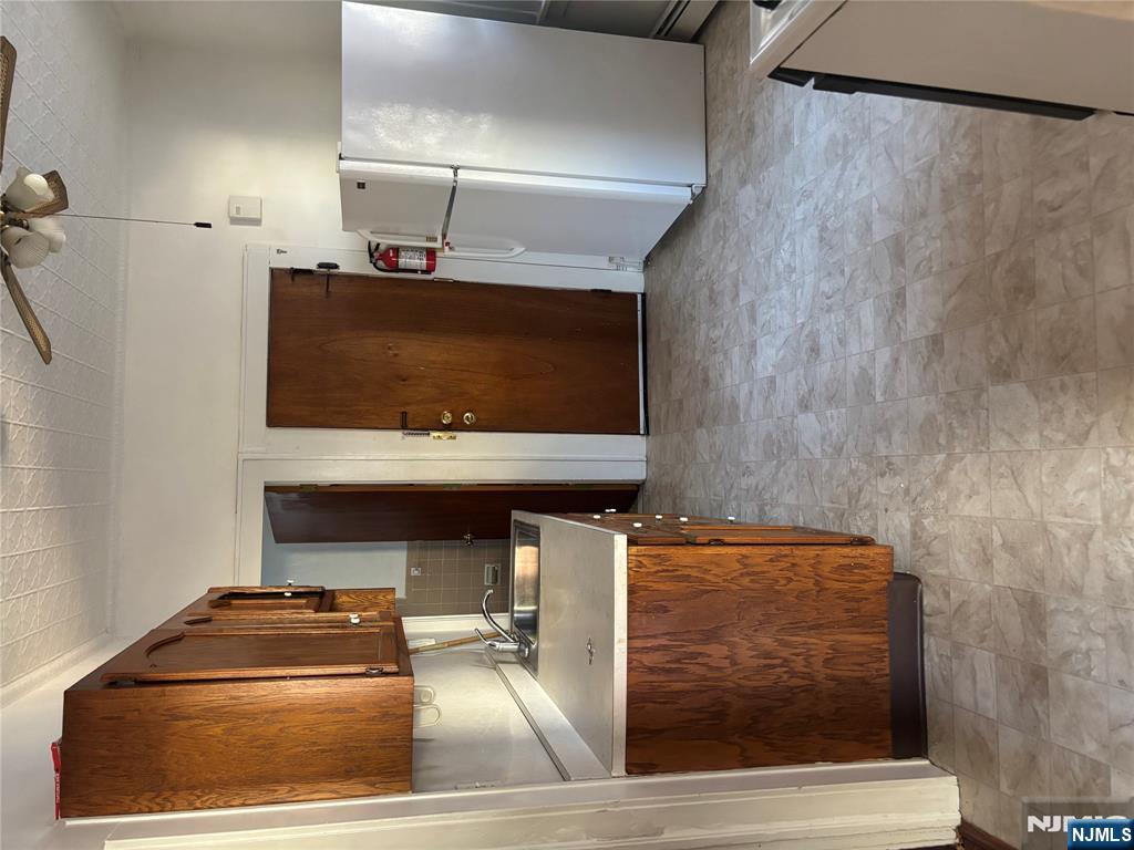 86 Center Street, Unit 2R Clifton, NJ 07011 - Photo 3 of 8 a kitchen with refrigerator and cabinets