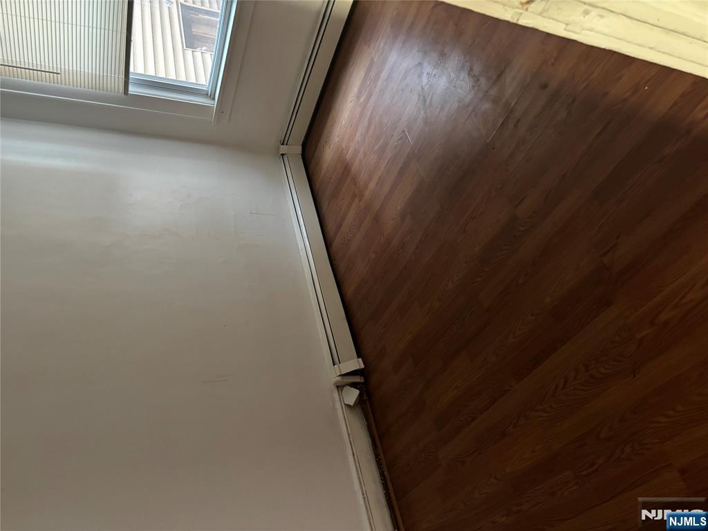 86 Center Street, Unit 2R Clifton, NJ 07011 - Photo 5 of 8 an empty room with wooden floor and windows