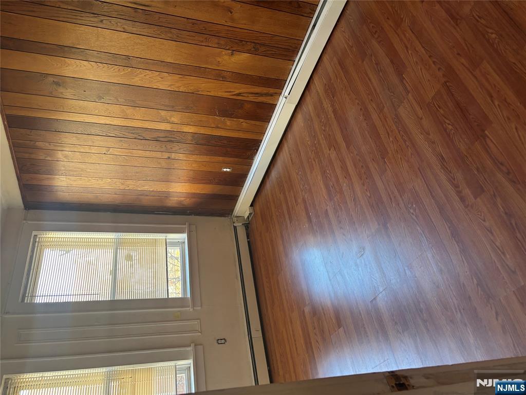 86 Center Street, Unit 2R Clifton, NJ 07011 - Photo 6 of 8 an empty room with wooden floor and windows with curtains