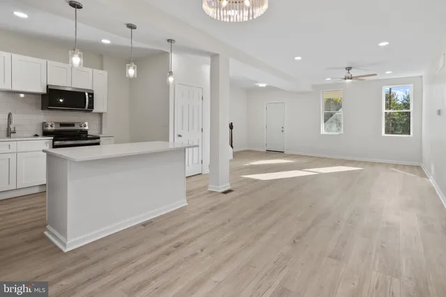a view of kitchen with stainless steel appliances granite countertop a stove a sink and a refrigerator