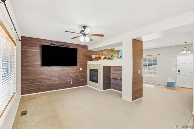 a view of an empty room with a flat screen tv and a ceiling fan