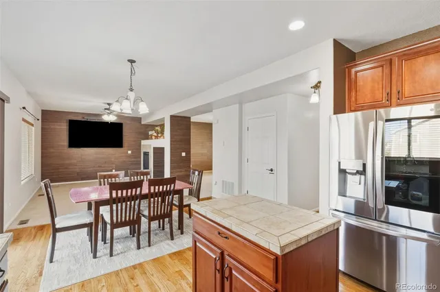 a dining room with stainless steel appliances kitchen island granite countertop a dining table chairs and a oven