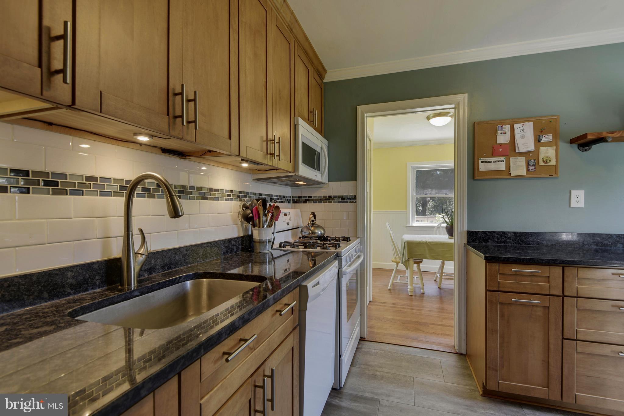 4412 Bennion Road Silver Spring, MD 20906 - Photo 9 of 29 a kitchen with granite countertop a sink a stove and cabinets