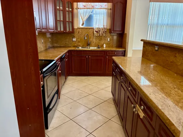 a kitchen with stainless steel appliances granite countertop sink stove and refrigerator