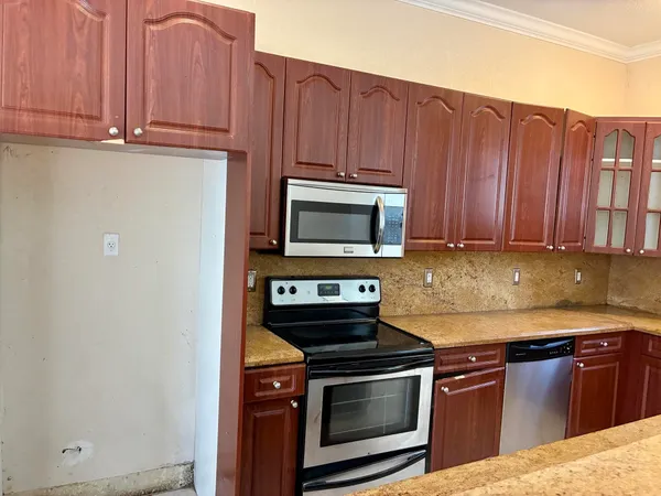 a kitchen with stainless steel appliances granite countertop a stove top oven microwave and cabinets