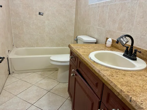 a bathroom with a granite countertop toilet sink and mirror