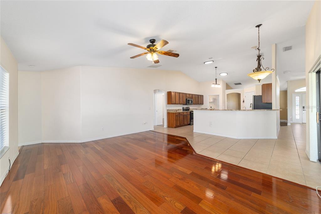 4037 Southeast 40th Street Ocala, FL 34480 - Photo 17 of 38 a view of a kitchen with wooden floor and a ceiling fan
